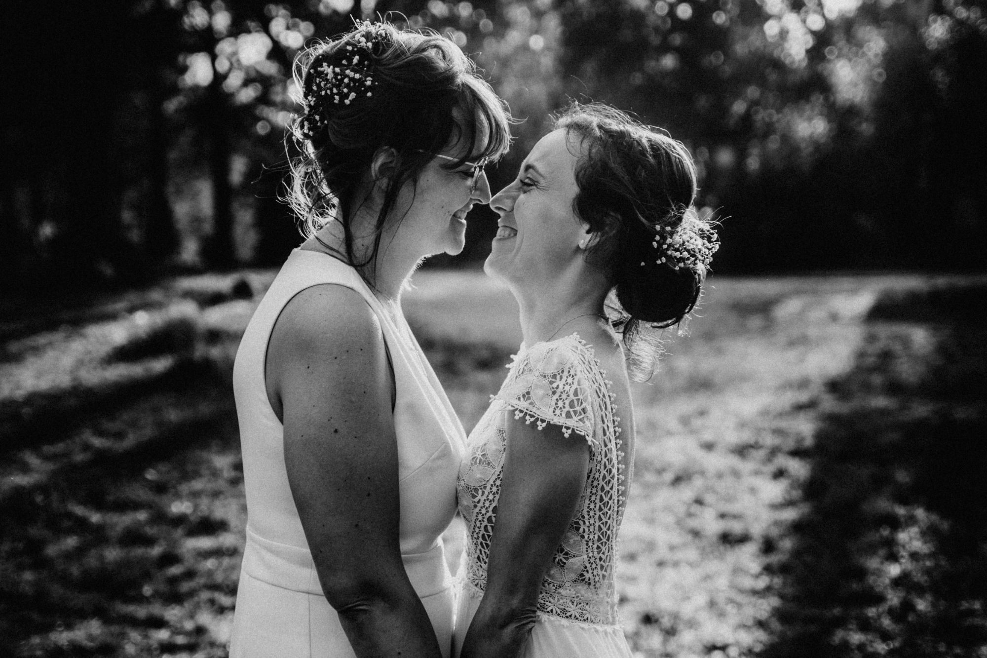 Deux mariées front contre front, souriantes, photo noir et blanc