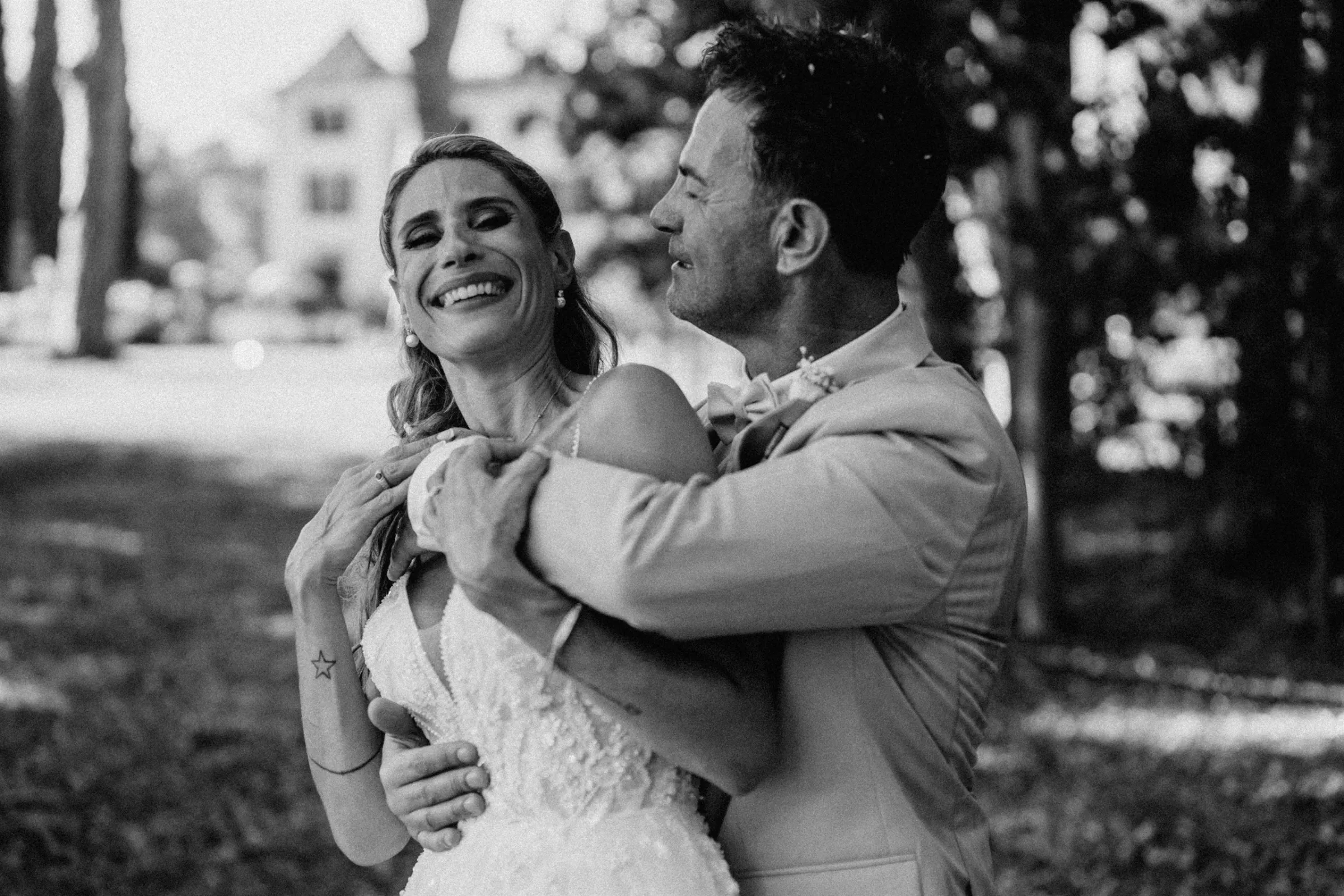 La mariée éclate de rire dans les bras du marié, photo noir et blanc