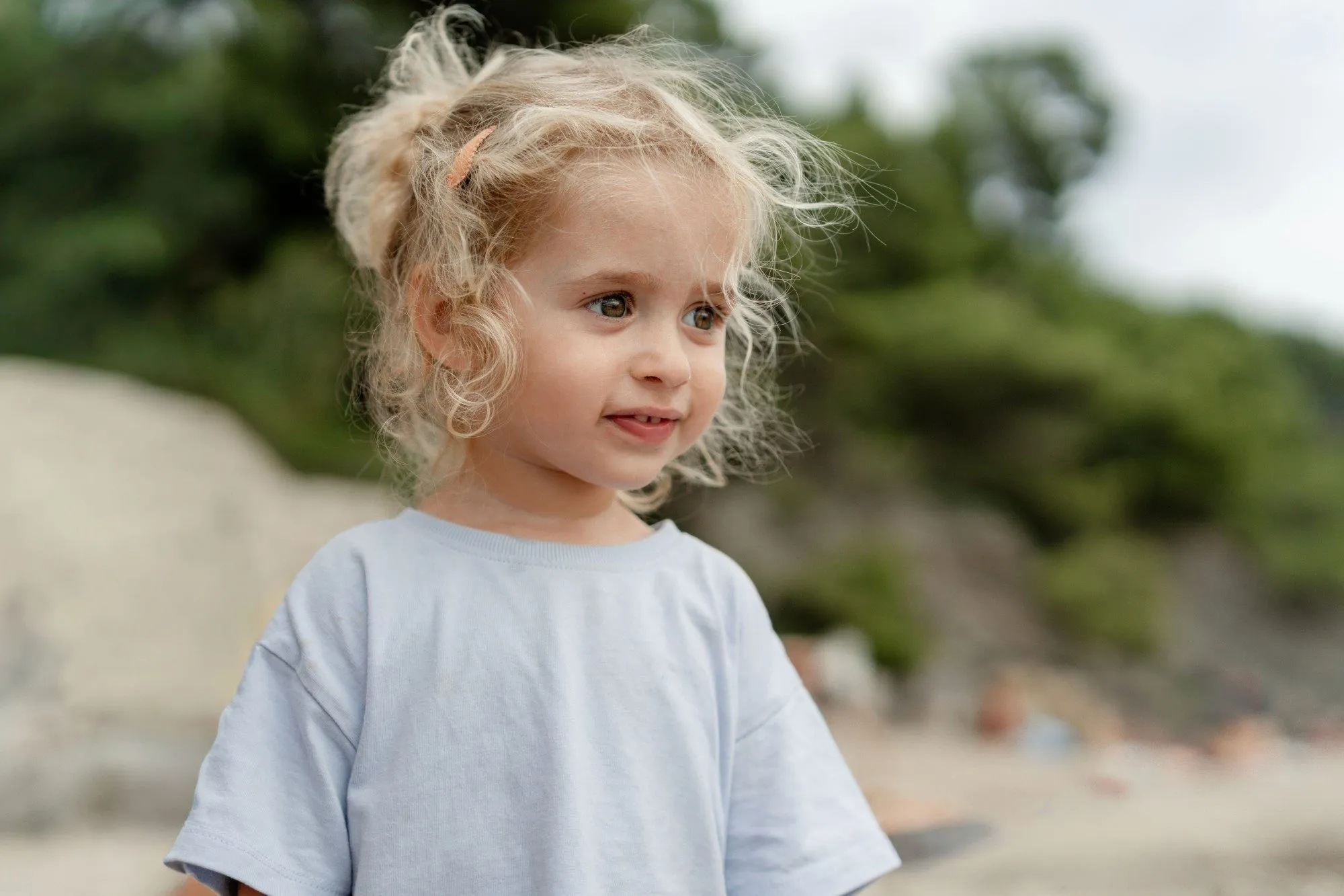 Séance photo famille en bord de mer : portrait d’une petite fille aux cheveux bouclés
